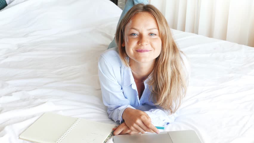 Beautiful Caucasian Woman Working On Laptop In The Bedroom