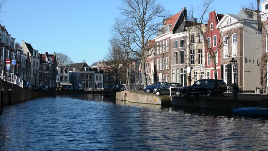 Old traditional Dutch houses reflecting in water in Leiden on a sunny winter day, South Holland, Netherlands - HD stock footage clip