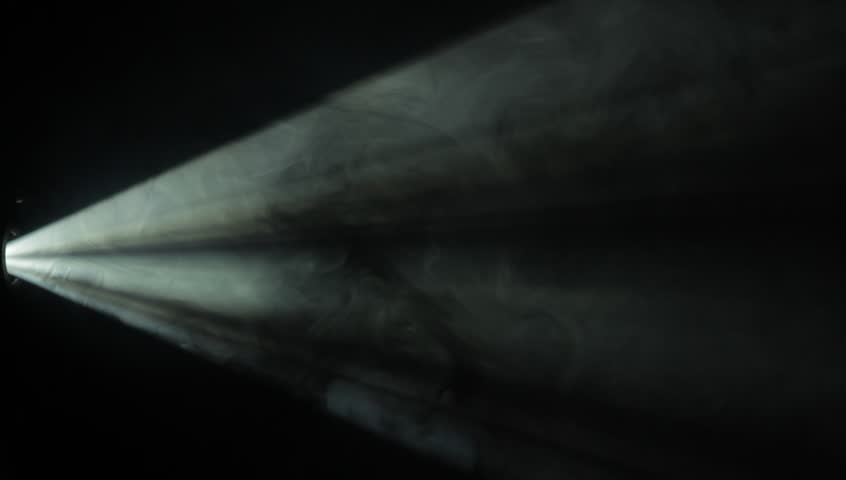 jib shot moving through the light beam of a 35mm projector projector light beam