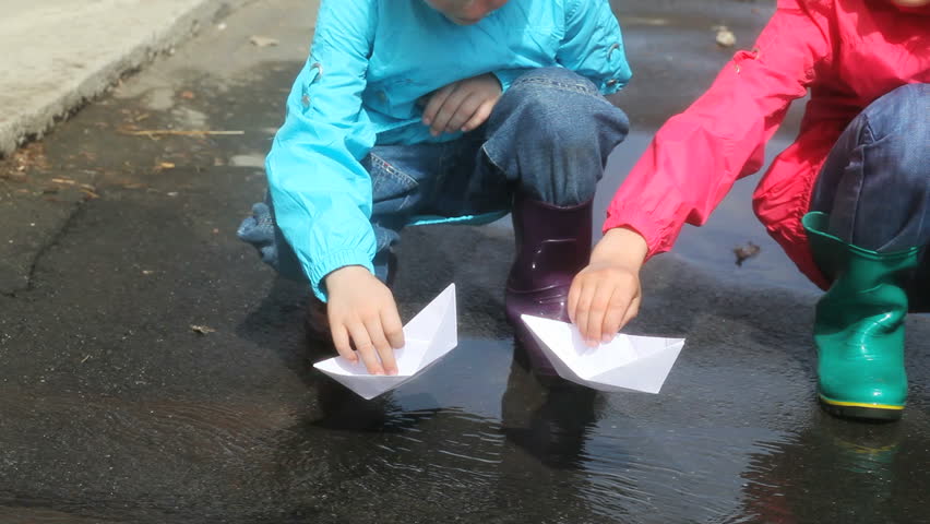 Children Playing With Paper Boats After The Rain Stock
