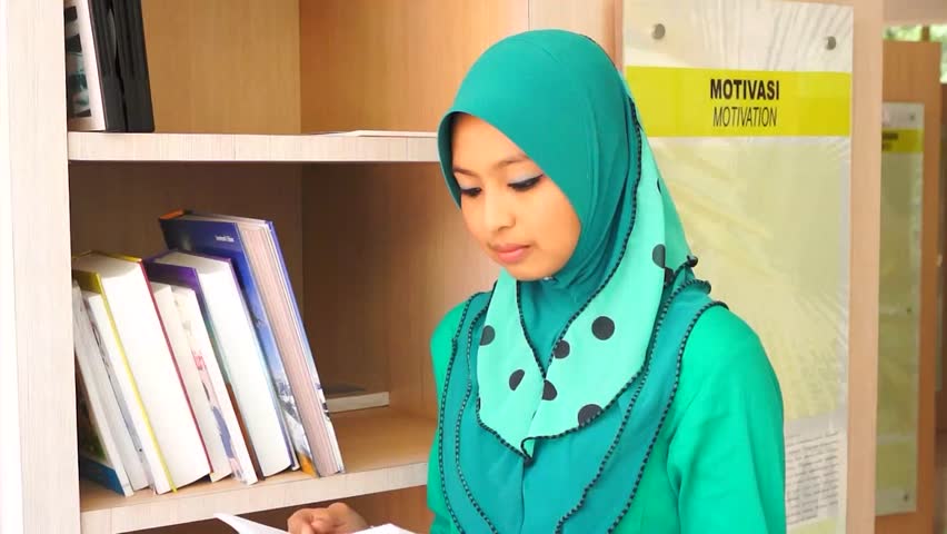 student at the library reading book and smile to the student at the library reading book and smile to the