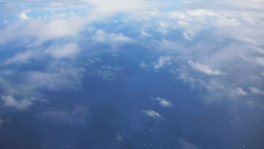 Flying In Airplane Over Pacific Ocean And Clouds Showing Earths