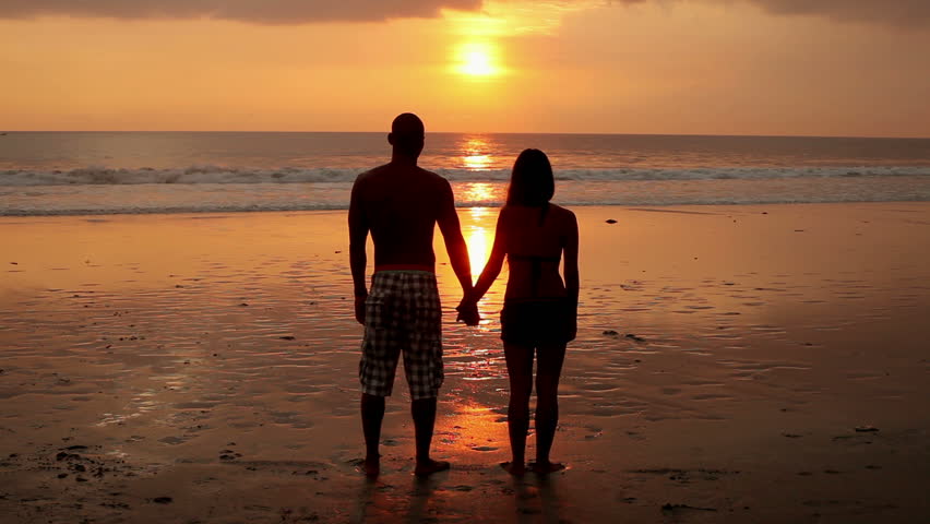 Silhouetted Couple Holding Hands On The Beach In The Sunset Stock Footage Video 3632810
