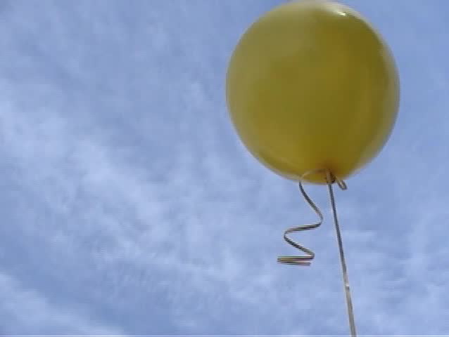 A Yellow Helium Balloon Floats Away In The Wind Against A Blue Spring ...