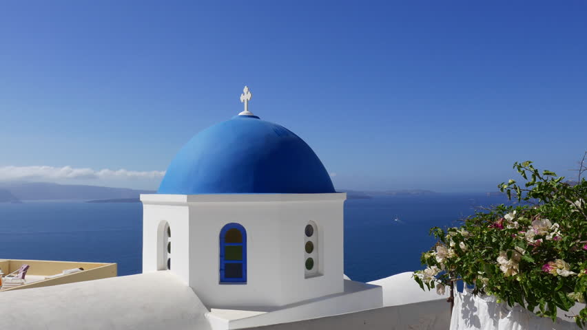 A White Washed Church With A Blue Dome Overlooking The Aegean Sea And ...