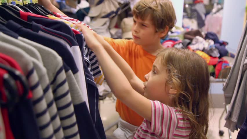 Two Kids Boy With Little Girl Take And Watch Shirts In Clothes Shop ...
