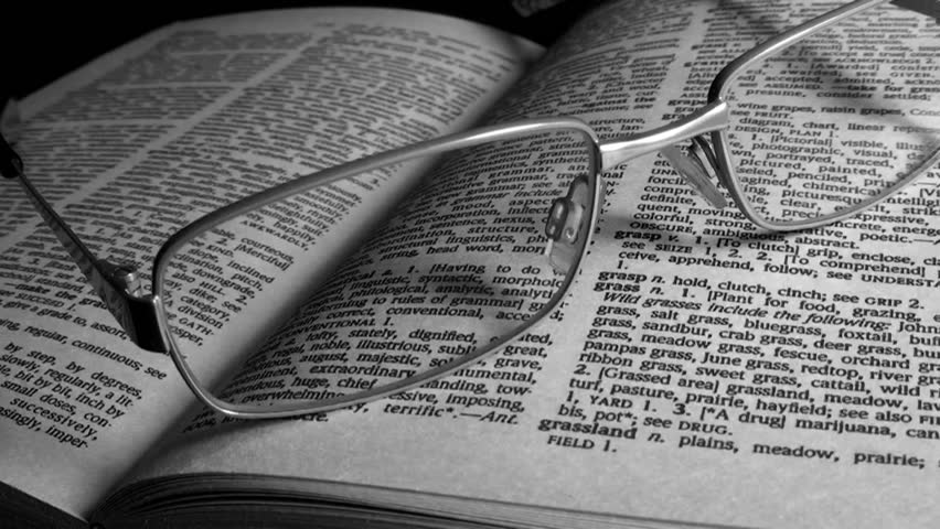 Reading Glasses On A Book (a Dictionary), With Dramatic Lighting. Black ...