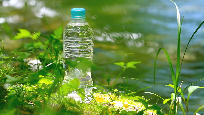 Pet Bottle Of Mineral Water In Forest With Clean Water Stream In ...