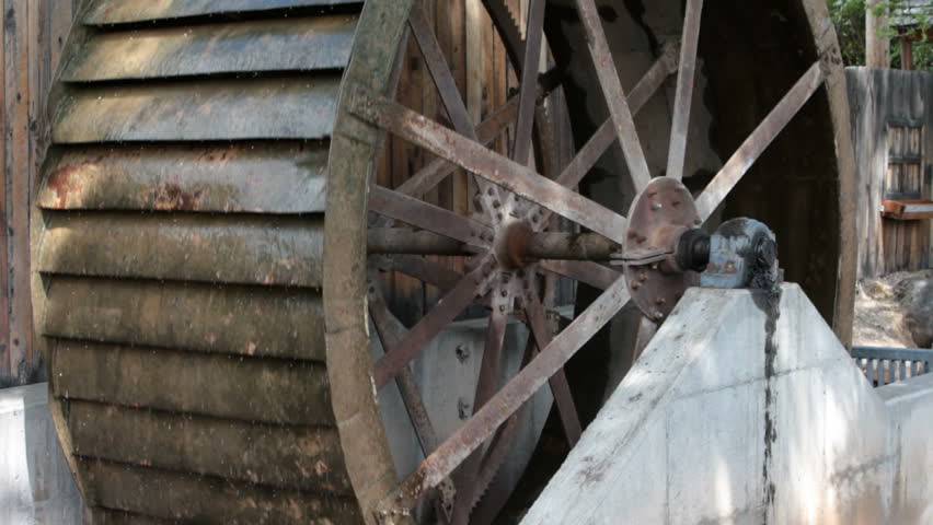 Old Antique Water Wheel Turning Against A Wood Building. Water Diverted ...