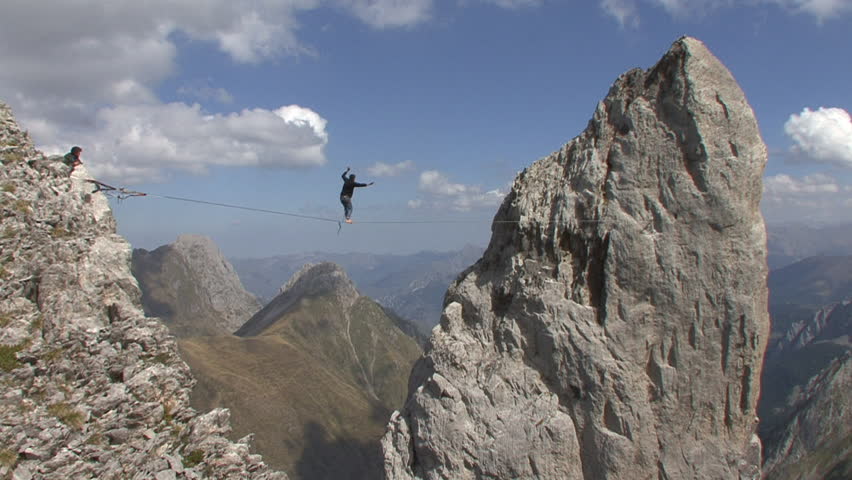 France, 2013. A Man Tightrope Walking Between Mountain Peaks. Stock ...