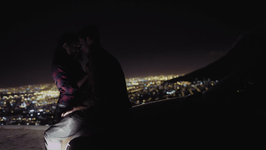 Romantic Couple In Car Share A Kiss As They Drive Through The City ...